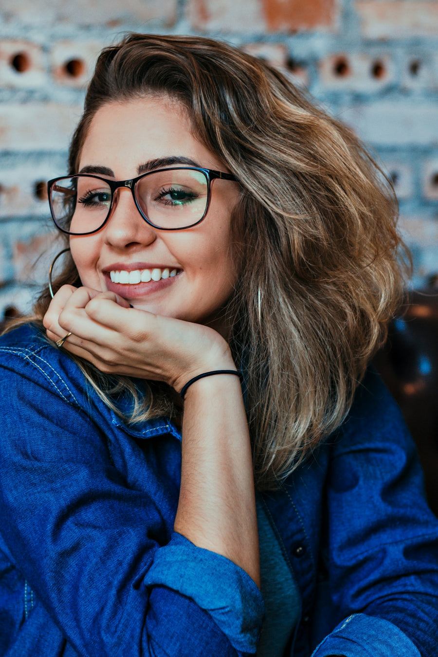 Mujer sonriendo con gafas de marco negro